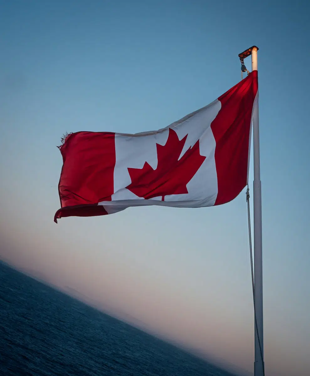 Canadian flag flying over the ocean